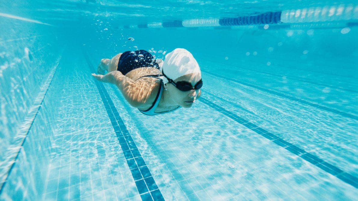 Young woman swimming in a pool underwater